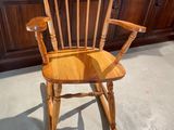 a wooden rocking chair in the middle of a kitchen