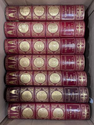 une boîte remplie de livres rouges ornés de dorures