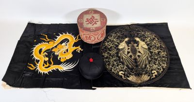un chapeau et une souris posés sur un tapis orné d'un dragon
