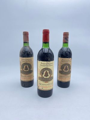 trois bouteilles de vin posées les unes à côté des autres sur une surface blanche