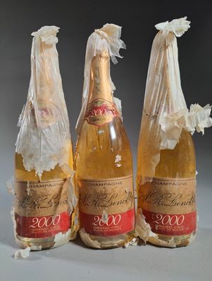 trois bouteilles de vin emballées dans du plastique, posées sur une table