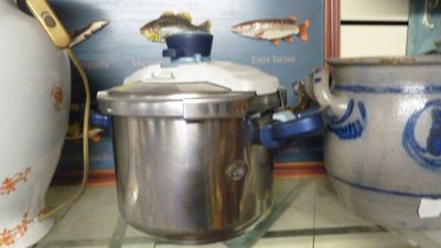 des casseroles et des poêles posées sur une étagère dans une cuisine