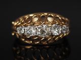 gros plan d'une bague en or et diamants sur une surface noire