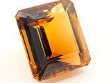 un gros plan d'un saphir orange sur une surface blanche