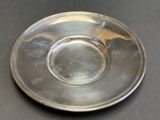 a silver plate on a table with a black background