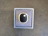 une image représentant une bague sertie d'une pierre noire