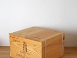 wooden crate with lid on wooden table with white wall in background