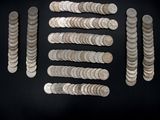 a close up of a bunch of silver coins on a black surface