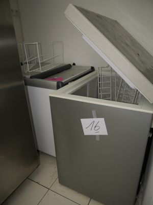 a silver refrigerator with a sign on it in a kitchen