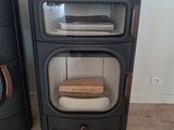 une cuisinière et un micro-ondes dans une pièce équipée d'un poêle à bois
