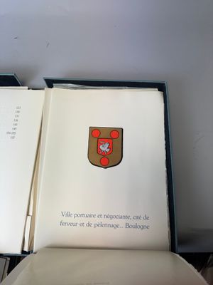 un livre ouvert sur lequel figure un blason