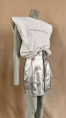 the mannequin is wearing a silver skirt and a white shirt