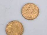 two gold coins sitting next to each other on a white surface