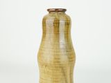 a brown vase that is sitting on a white surface
