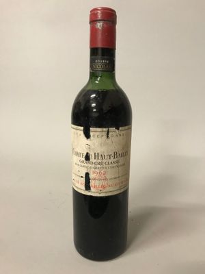une vieille bouteille de vin posée sur une table blanche