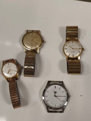 Trois montres sont posées les unes à côté des autres sur une surface blanche.