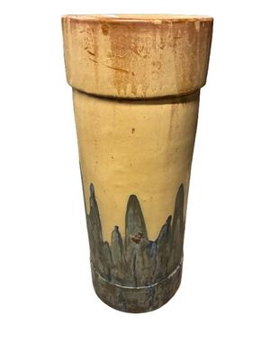 un vase jaune orné d'un motif noir