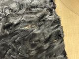 a close up of a black dog ' s fur on a table
