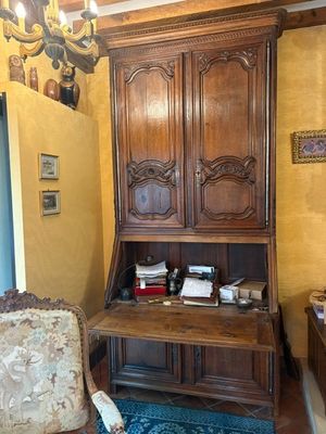 une armoire en bois dans un coin d'une pièce où se trouve un tapis bleu