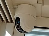 a white security camera mounted on the side of a building