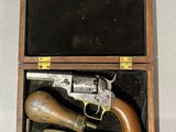 a small wooden box with a gun inside of it