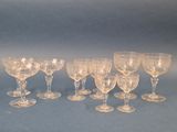 several clear wine glasses are lined up on a blue surface