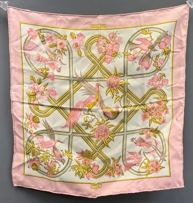 a pink silk scarf with birds and flowers on it