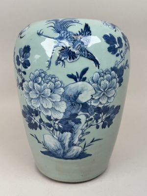 un vase bleu et blanc orné d'un oiseau et de fleurs