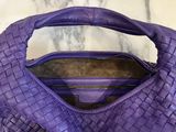 purple leather handbag on marble counter top with zippers