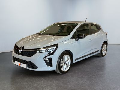 Une voiture blanche est garée dans une pièce au sol gris.