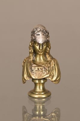 une statue en or représentant une femme, posée sur une table en verre