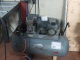 deux compresseurs d'air dans un garage, avec une échelle