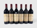 six bottles of wine are lined up in a row on a white surface