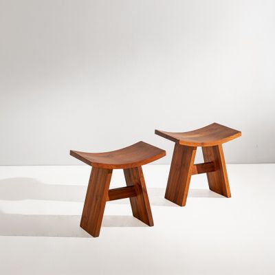 deux petits tabourets en bois posés sur une surface blanche