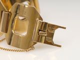 a gold bracelet with a chain attached to it