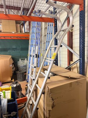 un chariot avec des cartons et une échelle dans un entrepôt