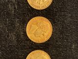 trois pièces d'or empilées les unes sur les autres sur un tissu noir