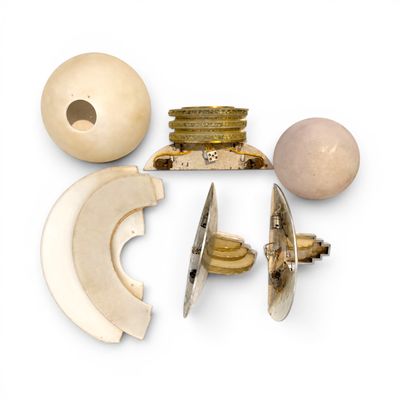 un gros plan sur un objet blanc avec une boule en bois et d'autres objets