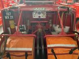 a red fire truck with two bags on the back of it