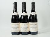 trois bouteilles de vin posées sur une table blanche