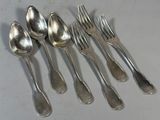 six cuillères et six fourchettes en argent sont alignées sur une table