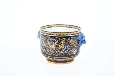 une tasse noire et dorée avec une anse bleue