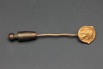un gros plan d'un objet métallique sur lequel repose une pièce de monnaie