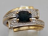 a close up of a ring with a sapphire and diamonds