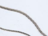 a silver chain that is laying on a white surface