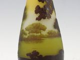 a yellow and black vase sitting on a white surface