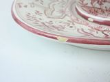 a pink and white plate with a cup and saucer on it