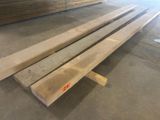 plusieurs pièces de bois sont empilées dans un entrepôt