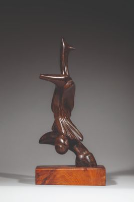 statue d'une femme tenant un oiseau, posée sur un socle en bois