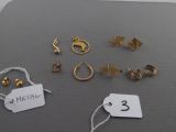 a lot of gold earrings and tags on a table